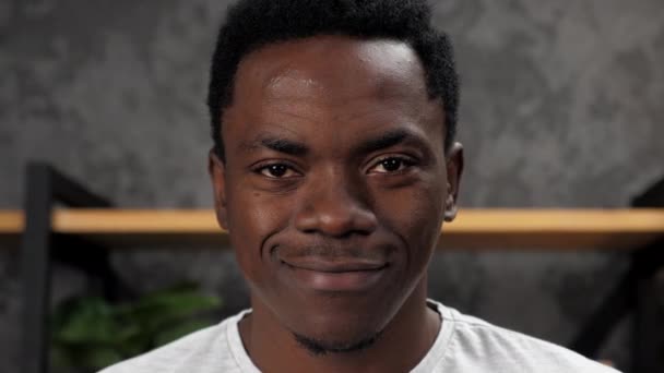 De cerca la cara sonriente hombre afroamericano mirando cámara, de pie en la oficina — Vídeos de Stock