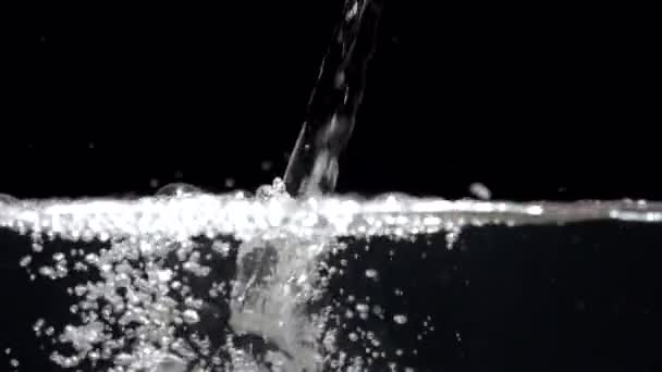 Zpomalený proud vody kape v akváriu na černém pozadí — Stock video