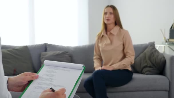 Μη εστιασμένη γυναίκα με πρόβλημα ψυχικής υγείας κάθεται στον καναπέ μιλώντας με τον θεραπευτή — Αρχείο Βίντεο