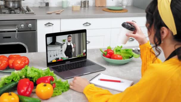 Man food blogger in computer screen shows slice cucumber tells teaches housewife — Stock Video