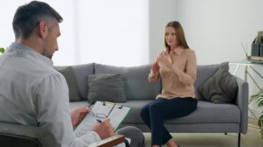 Ruh sağlığı sorunları olan, terapistle konuşan odaksız, sinirli bir kadın.