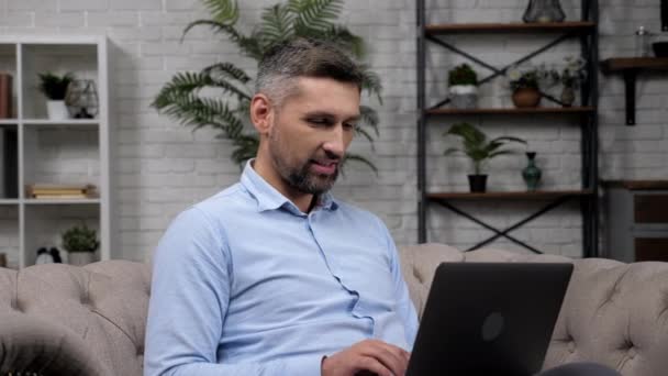 Uśmiechnięty człowiek makler giełdowy pracuje dla laptopa czat online z inwestorem — Wideo stockowe
