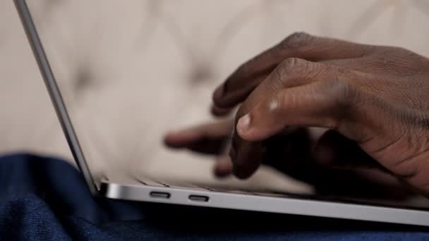 Закройте руки афроамериканца, печатающего текст на клавиатуре дома — стоковое видео