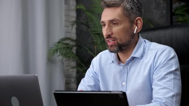 Homme souriant courtier négociant en actions parle webcam ordinateur portable en ligne chat avec les investisseurs — Video