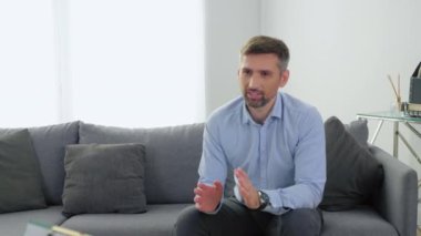 Ruh sağlığı sorunu olan duygusal gülümseyen bir adam terapistle konuşuyor.