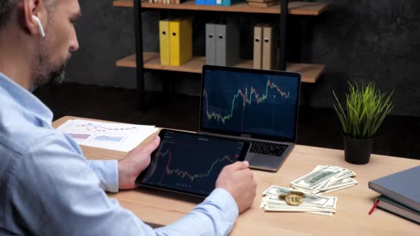 Hombre broker looks tablet with stock exchange chart laptop with stock market chart — Vídeo de stock