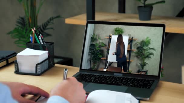 Бізнесмен пише в блокноті, вивчає бізнес онлайн-курс веб-камера ноутбуків — стокове відео