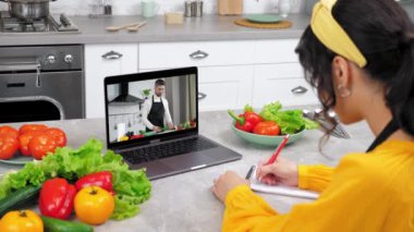 Evde çalışan bir kadın çevrimiçi video görüntüsü için webcam laptop dinle şef öğretmen