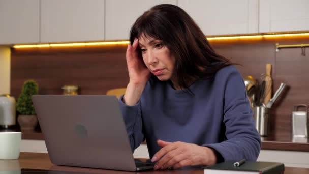 Εξαντλημένη γυναίκα χρησιμοποιεί φορητό υπολογιστή αισθάνεται ανήσυχος διαβάζοντας άσχημα νέα στα μέσα κοινωνικής δικτύωσης — Αρχείο Βίντεο