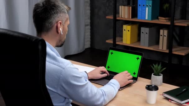 Ο μεσίτης αποθεμάτων ατόμων εργάζεται για το lap-top με την πράσινη δακτυλογράφηση οθόνης στο πληκτρολόγιο — Αρχείο Βίντεο
