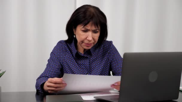 Недовольная деловая женщина рассматривает финансовые отчеты компании по продажам, домашний офис — стоковое видео