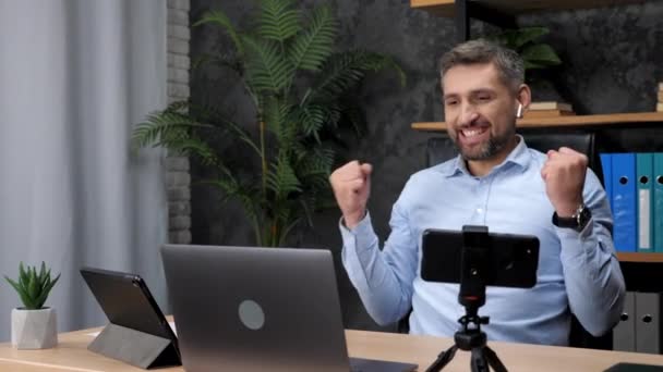 Vencedor empresário animado parece laptop celebrando boa renda da empresa, escritório — Vídeo de Stock