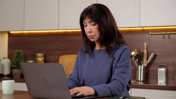 Yorgun iş kadını dizüstü bilgisayar için çalışıyor. Bilgisayarda uzun süre çalıştıktan sonra gözlerini ovuşturuyor. — Stok video