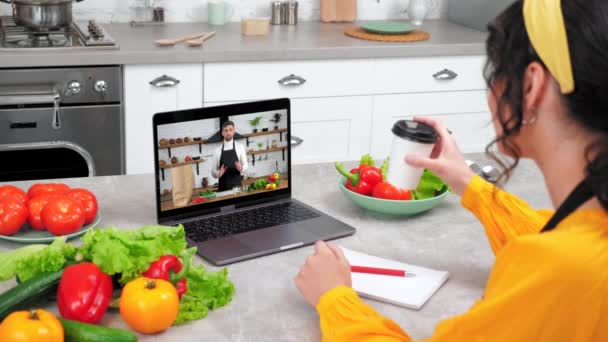 Мужчина шеф-повар пищевой блоггер в ноутбуке рассказывает преподает женщине видео звонок кулинарный урок — стоковое видео