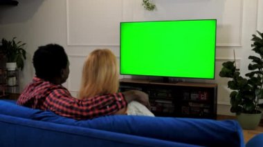 Yeşil ekran TV çok ırklı aile çifti TV 'de film izlerken kucaklaşıyor