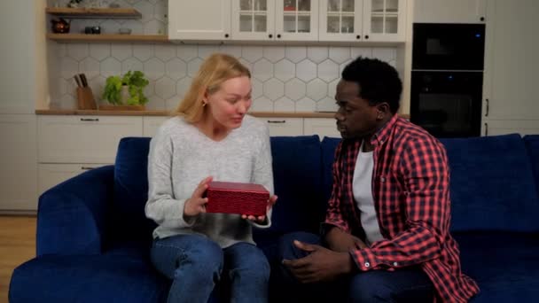 African American man boyfriend gives gift box girlfriend caucasian woman, couple — стокове відео