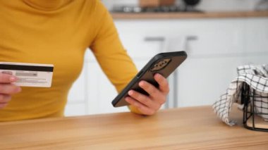 Kadın internet üzerinden akıllı telefon almak için kredi kartı koduna giriyor.