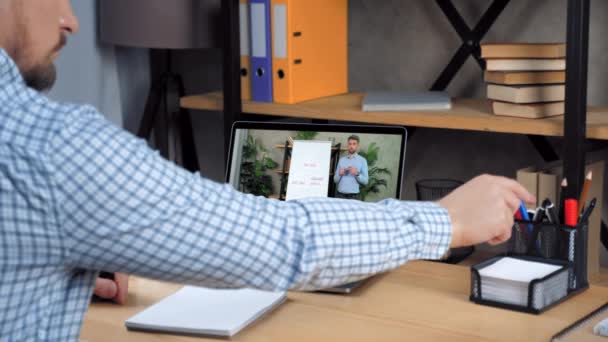 Zakenman op kantoor thuis luisteren online video call laptop, schrijft in notebook — Stockvideo