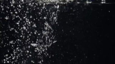 Akvaryumda yavaş hareket eden su akımı siyah bir arkaplanda düşer.