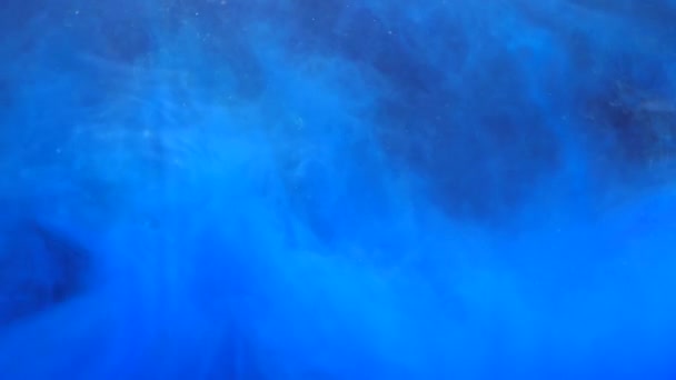 Повільний рух синього чорнила акрилова фарба змішується у воді, м'яко крутиться під водою — стокове відео