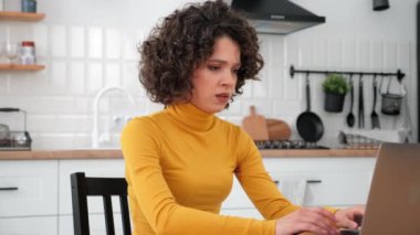 Yorgun kıvırcık kız öğrenci çalışması, problem çözme konusunda dizüstü bilgisayar kullanıyor.