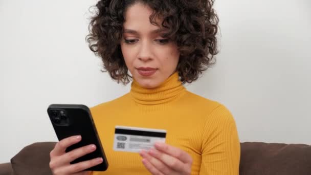 Kobieta wpisuje kod karty kredytowej, aby zapłacić prezenty zakupy online za pośrednictwem smartfona — Wideo stockowe