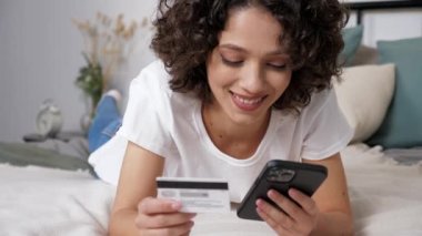 Kadın hediye ödemek için kredi kartı koduna giriyor. İnternet üzerinden akıllı telefon alıyor.