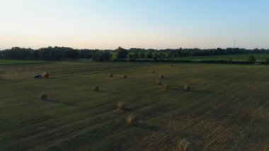 Yazın gün batımında tarım alanında hava manzaralı saman balyaları. İnsansız hava aracı samanlığı vurdu ve tarım için kuru ot hasat etti. Saman balyalarının üzerinde uçmak. Ekinleri biçip biçmek için çiftçiler mevsimi