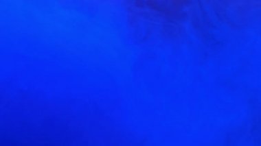 Suya karışan mavi mürekkep akrilik boya, suyun altında yavaşça dönüyor. Akvaryumda renkli akrilik boya bulutu. Soyut duman patlaması animasyonu. Güzel sanat arka planı