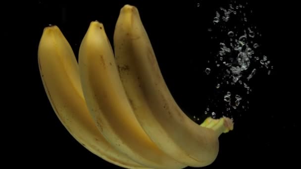 Μπανάνες Αργής Κίνησης Πέφτουν Διάφανο Νερό Μαύρο Φόντο Φρέσκα Φρούτα — Αρχείο Βίντεο