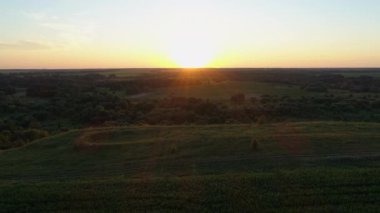 Hava manzaralı gün batımı ya da tarlada gün doğumu. İnsansız hava aracı güzel bir yaz akşamı ya da sabah güneşini ormanda çeker.
