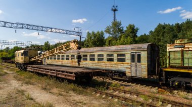 Çernobil nükleer santrali yakınlarındaki Pripyat şehrindeki orman içinde terk edilmiş paslı tren ve vinç çöplüğünün havadan görüntüsü. İnsansız hava aracı güneşli bir günde yaz aylarında Yasak Bölge 'yi vurdu. Radyasyon