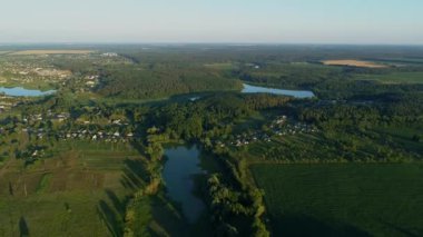Yazın hava manzarası çok güzel. Güneşli bir günde mısır tarlasında uçan insansız hava aracı. Drone köyde doğa, orman ve gölet vurdu.