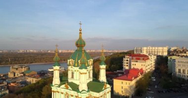 Aerial view Kyiv St. Andrews Church at beautiful sunset. Drone flies over old Kiev - podil. Andrews Descent