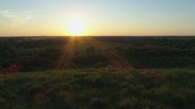 Havadan anne ve oğul bir dağ yamacında durup gün batımını ya da güneşin doğuşunu seyrediyorlar. İnsansız hava aracı güzel bir yaz akşamı ya da sabah güneşi tarlada.