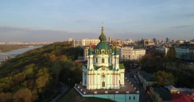 Aerial view Kyiv St. Andrews Church at beautiful sunset. Drone flies over old Kiev - podil. Andrews Descent