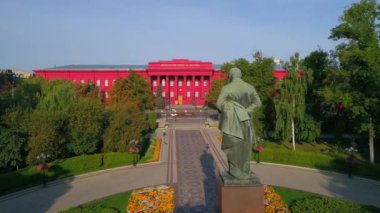 Yazar Taras Grigorovich Shevchenko 'nun güneşli bir bahar gününde parktaki hava manzaralı heykeli. Drone, Taras Shevchenko 'daki Kyiv Ulusal Üniversitesi' nin ön cephesinde kırmızı bina görüntüsü çekti. Ukrayna 'nın başkenti