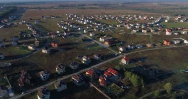 Drone flies over a small village in a field, aerial view building