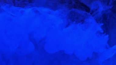 Suya karışan mavi mürekkep akrilik boya, suyun altında yavaşça dönüyor. Akvaryumda renkli akrilik boya bulutu. Yavaş çekim soyut duman patlaması animasyonu. Güzel sanat arka planı
