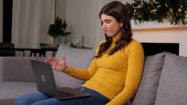 Angry businesswoman looks at laptop screen display upset about problem of gifts for New Year. Stressed beautiful woman student read bad online news on computer at cozy home