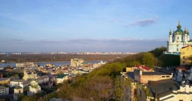 Aerial view Kyiv cityscape left bank of the Dnipro River at beautiful sunset or sunrise. Drone flies over old Kiev - podil. St. Andrews Church, Andrews Descent