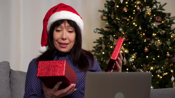Ηλικιωμένη Γυναίκα Καπέλο Του Βασίλη Ανοίγει Κόκκινο Κουτί Δώρου Και — Αρχείο Βίντεο
