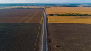 Aerial view beautiful summer nature landscape on a sunny day. Drone shot new road between a field. Blue sky
