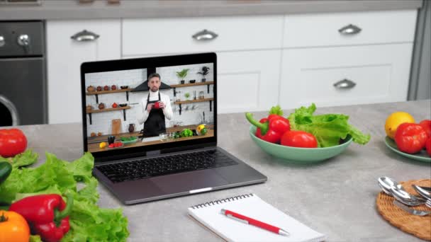 电脑上的屏幕显示器显示 学生们站在厨房桌子上 旁边的食物配料和笔记本上都有铅笔 网上视频称为烹饪课 — 图库视频影像