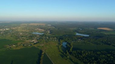 Yazın hava manzarası çok güzel. Güneşli bir günde mısır tarlasında uçan insansız hava aracı. Drone köyde doğa, orman ve gölet vurdu.