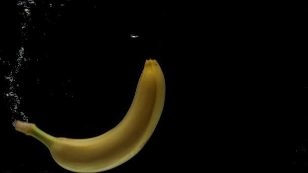 Zwolniony Ruch Jeden Banan Wpadający Przezroczystej Wody Czarnym Tle Świeże — Wideo stockowe