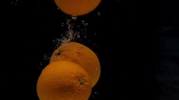 Yavaş Çekim Portakal Siyah Arkaplanda Şeffaf Suya Düşüyor Akvaryuma Taze — Stok video