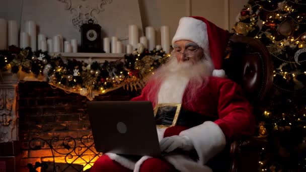 Modern Santa Claus Uses Laptop Fills Holiday Cards Children Background — Stock Video