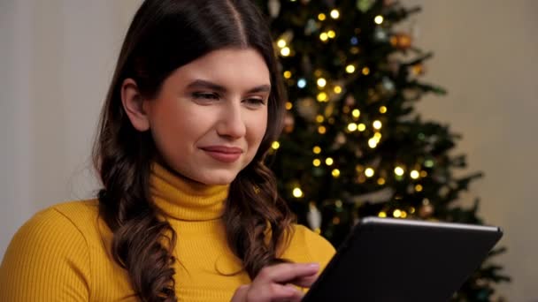 Жінка Яка Посміхається Купує Подарунки Нового Року Інтернеті Використовуючи Планшет — стокове відео