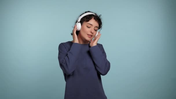 Portret Lachende Jonge Krullende Vrouw Luistert Naar Muziek Koptelefoon Dansen — Stockvideo
